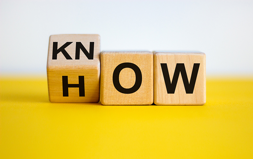 Know how and business concept. Turned cube and changed the word 'how' to 'know'. Beautiful yellow table, white background.